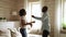 Happy funky young african couple dancing jumping in living room