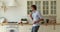 Happy funky young guy having fun preparing food in kitchen.