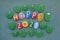 Happy Funny 2021 with multi colored stone letters and green monsters design