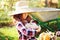 happy funny child girl in farmer hat and shirt playing and picking autumn vegetable harvest in sunny garden