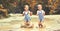 Happy funny sisters twins child by girl jumping on puddles and laughing