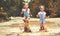 Happy funny sisters twins child by girl jumping on puddles and laughing