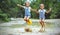 Happy funny sisters twins child girl jumping on puddles in rub