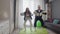 Happy funny young healthy couple man and woman are working at home. They doing squats exercise