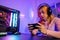 Happy Gamer playing video game online with smartphone with neon lights