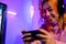 Happy Gamer playing video game online with smartphone with neon lights