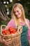 Happy gardener carrying fresh tomatoes basket at garden