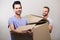 Happy gay couple holding boxes