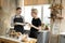 Happy gay couple, one asian with blonde hair in glasses second european in casual wear having breakfast in the kitchen