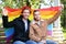 Happy gay couple with rainbow LGBT flag in park