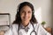 Happy general practitioner in headphones giving online help