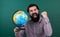 Happy geographer man with beard look at globe. ready for studying. nonformal education. student in school classroom