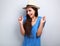 Happy giggling young woman with straw hat on blue background loo