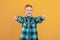 Happy ginger kid showing thumbs up on yellow studio background
