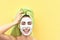 Happy girl applying facial clay mask - Young woman having skin care spa day - Beauty clean treatment day and cosmetology products