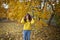 Happy girl in autumn forest with yellowing leaves