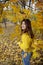 Happy girl in autumn forest with yellowing leaves