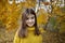 Happy girl in autumn forest with yellowing leaves