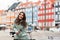 Happy girl on bicycle with beautiful colored old buildings on background