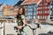 Happy girl on bicycle with beautiful colored old buildings on background