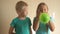 Happy girl in a blue T-shirt blows bright balloon in bathroom at home. Blond boy with needle pierces a balloon. shallow focus