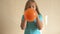 Happy girl in blue t-shirt inflates a bright orange ball in bathroom at home. Shallow focus