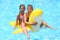 Happy girl and boy swim at the childrens inflatable toy