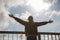 Happy  girl on the bridge and feeling free and looking at the blue river