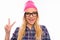 Happy girl in cap and glasses gesturing with two fingers and showing tongue
