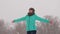 Happy girl catches snowflakes in winter park. girl walks in woods during a snowfall. Slow motion