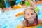 Happy girl child playing in the pool on a sunny day. Cute little girl enjoying holiday vacation