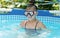 Happy girl child wear swimming mask in outdoor pool in summer, swim