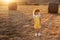 Happy girl child in yellow dress runs in autumn field
