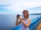 Happy girl on cruise liner making photo. Young woman with photocamera