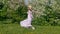 Happy girl dancing near blooming trees in garden at springtime