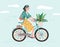 Happy girl dressed in trendy clothes riding city bicycle with flower bouquet in front basket. Adorable young hipster