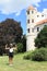 Happy girl in front of tower of castle in Telc