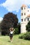 Happy girl in front of tower of castle in Telc