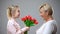 Happy girl giving flowers to grandmother, family tradition, holiday celebration