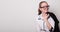 Happy girl in glasses puts on a jacket. Charming caucasian girl in glasses. Banner with an empty space for text