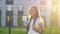 Happy girl goes to school smiling at back sunset light