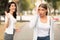 Happy girl greeting waving hand and friend ignoring her