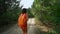 Happy girl hiker walking along rough ground road in woods