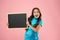 Happy girl hold blackboard pink background. cheerful child hold advertising board. Little schoolchild at lesson