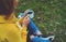 Happy girl holding in hands cup of hot tea on green grass in outdoors nature park top view, beautiful woman hipster enjoy drinking