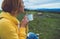 Happy girl holding in hands cup of hot tea on green grass in outdoors nature park top view, beautiful woman hipster enjoy drinking