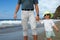 Happy girl holding man\'s hand on a beach