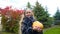 Happy girl holding pumpkin and posing for camera in Halloween cat costume