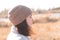 A happy girl in a knitted hat stands against a background and a coat against the backdrop of an autumn pale pond landscape