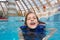 Happy girl in lifejacket in the clear blue water